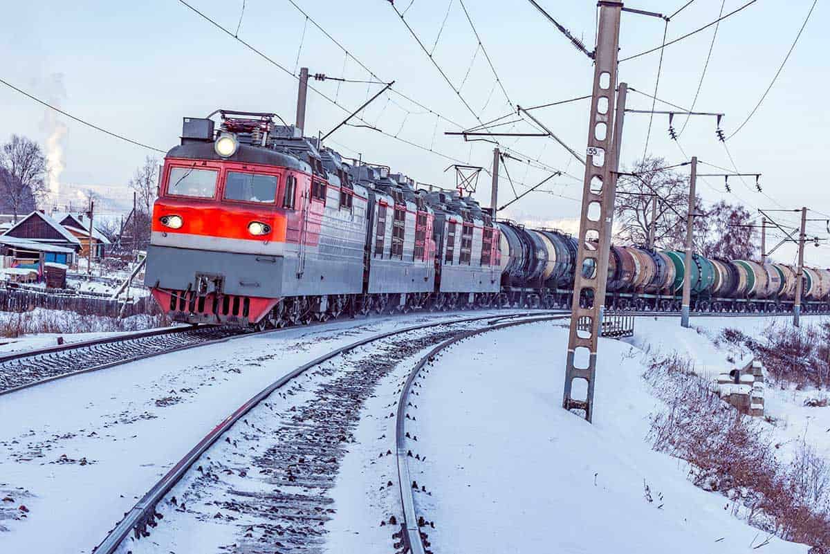 Ein Zug fährt über verschneite Gleise