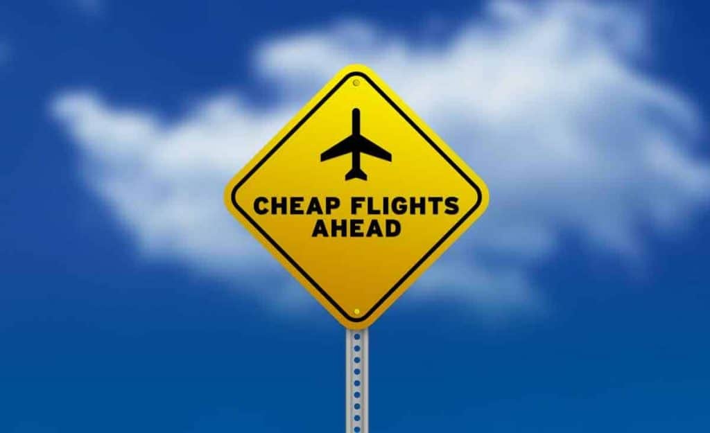 Ein Hinweisschild mit einem abgebildeten Flugzeug und der Aufschrift cheap flights ahead