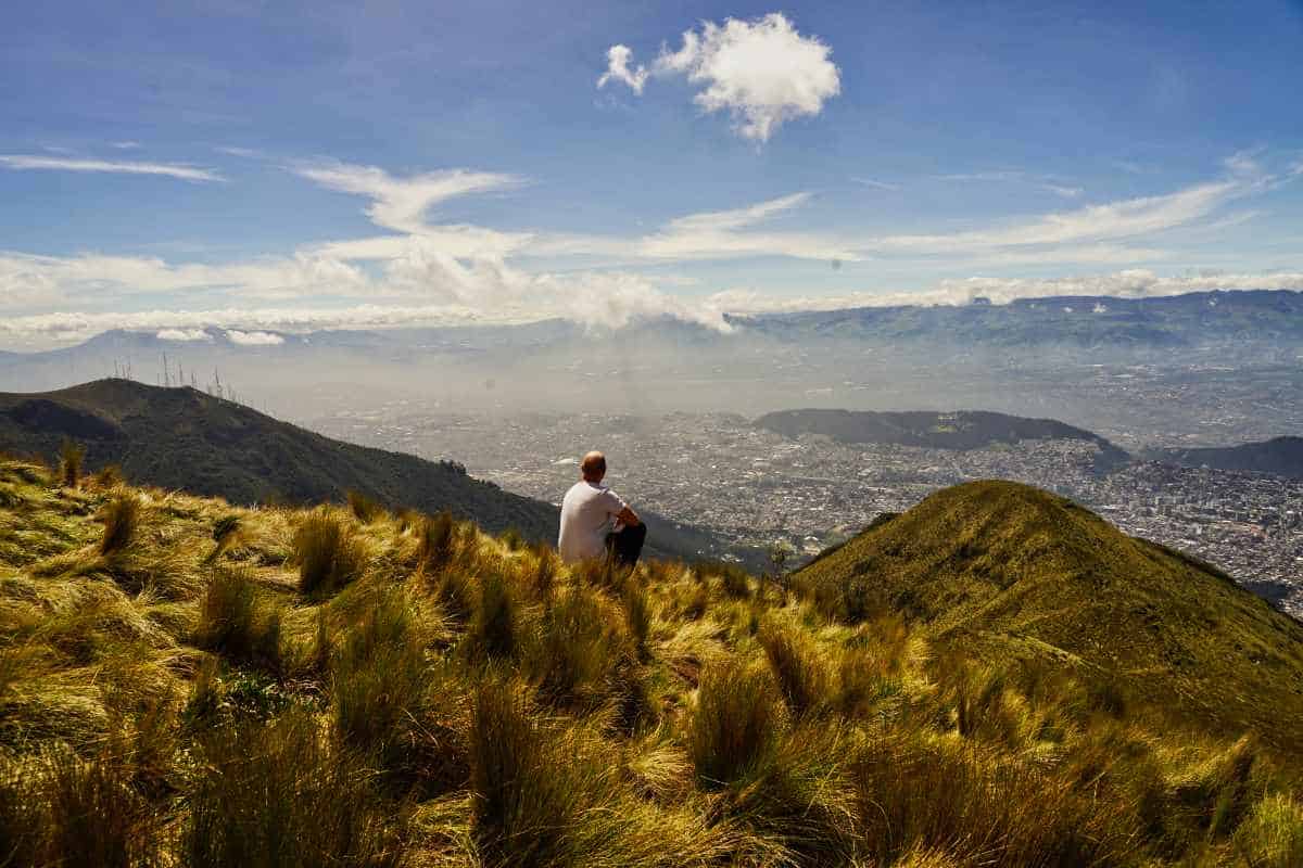 Ein Wanderer blickt vom Berg Pichincha ins Tal nach Quito