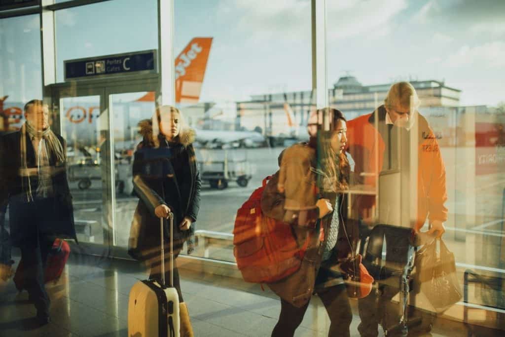 Reisende spiegeln sich in der Tür eines Flughafens